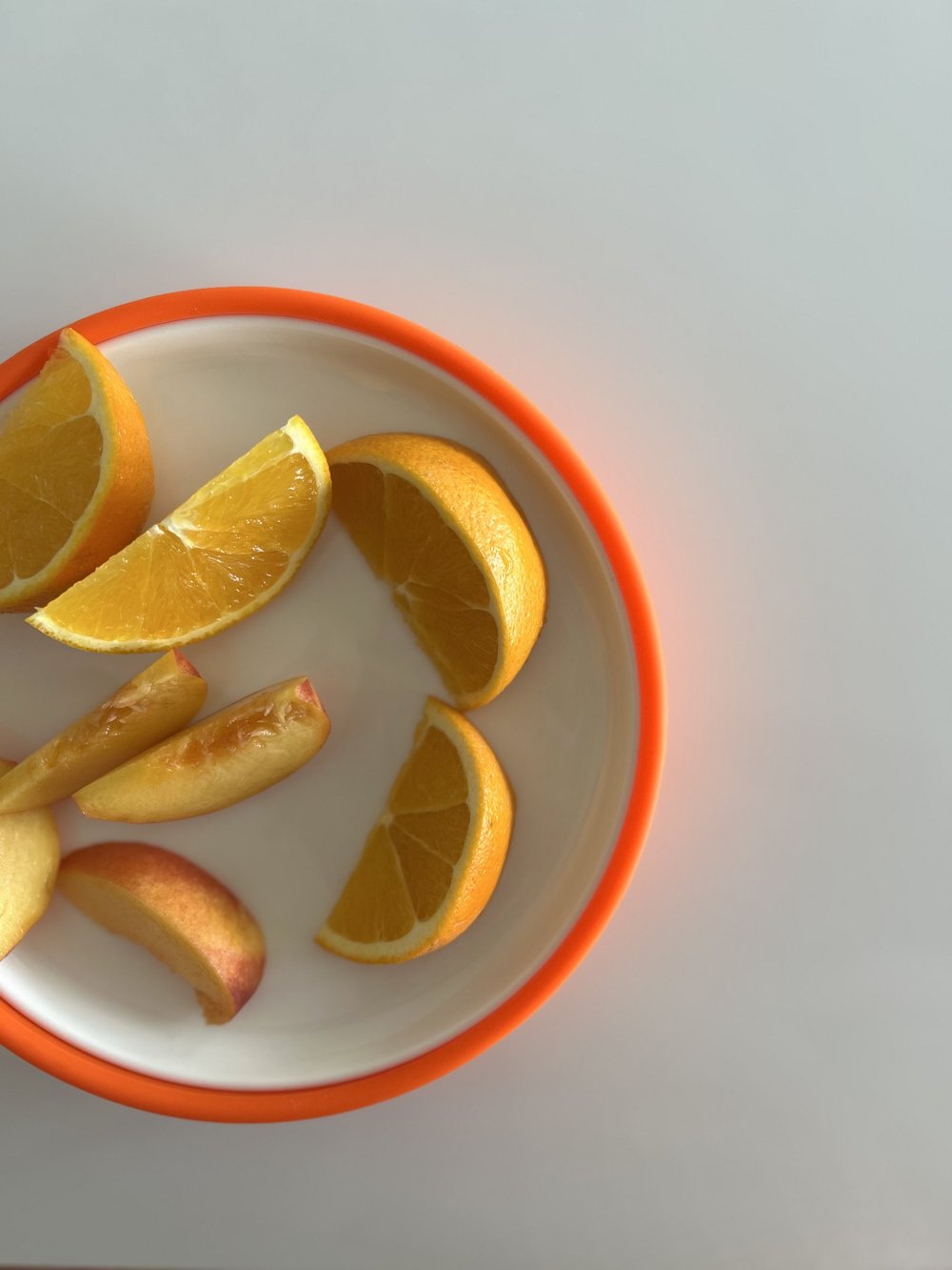 Orange slices on a ceramic plate in an orange Plate Mate